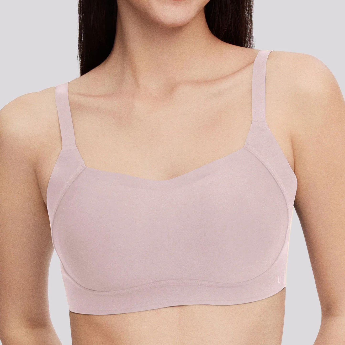 A woman wears the Side Support Back-Hook Bra in Pink by UBRAS